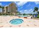 Tranquil hot tub and swimming pool surrounded by manicured landscaping and clear blue skies at 3040 Grand Bay Blvd # 234, Longboat Key, FL 34228