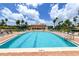 Stunning pool with lounge chairs, manicured landscaping, and inviting cool, blue water perfect for swimming at 3040 Grand Bay Blvd # 234, Longboat Key, FL 34228