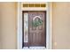 Charming front door with decorative wreath, sidelight window, and transom window above at 322 Capulet Dr, Venice, FL 34292