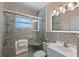 Modern bathroom featuring a glass enclosed shower, a vanity with an illuminated mirror, and light neutral tile at 3600 68Th N St, St Petersburg, FL 33710