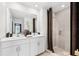 Modern bathroom featuring double sinks, large mirror, walk-in shower with neutral tile, and stylish fixtures at 3707 Ambersweet Crossing, Parrish, FL 34219
