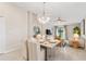 Cozy dining area featuring a modern chandelier, seating for four, and open access to the living room at 3707 Ambersweet Crossing, Parrish, FL 34219
