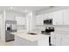 Modern kitchen features stainless appliances, white cabinetry, and a large island perfect for meal prep and dining at 3707 Ambersweet Crossing, Parrish, FL 34219