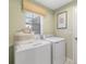 Functional laundry room with modern washer and dryer, plus convenient storage space at 3707 Ambersweet Crossing, Parrish, FL 34219