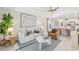 Open-concept living room with modern furniture, neutral tones, and ceiling fan leading into dining and kitchen areas at 3707 Ambersweet Crossing, Parrish, FL 34219