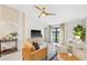 Bright living room with neutral tones featuring modern furnishings, TV, ceiling fan, and sliding glass doors at 3707 Ambersweet Crossing, Parrish, FL 34219