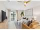 Bright living room featuring modern furniture, neutral tones, ceiling fan, and sliding glass doors to backyard at 3707 Ambersweet Crossing, Parrish, FL 34219