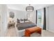 Stylish main bedroom features modern lighting fixture, decorative wall, mirrors, and window with natural light at 3707 Ambersweet Crossing, Parrish, FL 34219