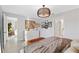 Stylish main bedroom featuring modern lighting fixture, decorative wall, ensuite access, and dresser at 3707 Ambersweet Crossing, Parrish, FL 34219