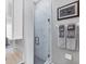 Modern bathroom featuring a tiled shower with a glass door, next to gray walls with decorative towels and artwork at 3826 Virga Blvd, Sarasota, FL 34233