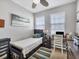 Bright bedroom featuring neutral paint, two windows, a ceiling fan, a desk, and a twin bed with a white coverlet at 3826 Virga Blvd, Sarasota, FL 34233