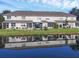 Back exterior view of the home that features a grassy yard, a serene pond, and covered patios at 3826 Virga Blvd, Sarasota, FL 34233