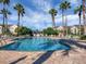 Community pool with plenty of seating surrounded by lush greenery and palm trees, perfect for relaxing and enjoying the weather at 3826 Virga Blvd, Sarasota, FL 34233