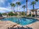 Sparkling community pool surrounded by palm trees, lush greenery, and lounge chairs for residents to relax and enjoy at 3826 Virga Blvd, Sarasota, FL 34233