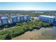 Scenic aerial view of waterfront condos, lush greenery, and tranquil waterways on a clear, sunny day at 396 Aruba Cir # 302, Bradenton, FL 34209