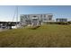 Bright exterior of a waterfront building with marina access and children playing on lawn at 396 Aruba Cir # 302, Bradenton, FL 34209