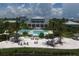 Beautiful pool area with a beach entrance, palm trees, lounge chairs, and a tiki hut at 396 Aruba Cir # 302, Bradenton, FL 34209