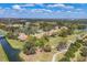 Scenic aerial view of a residential community with red-tiled roofs, winding paths, waterways, and verdant landscaping at 4416 Calle Serena, Sarasota, FL 34238