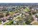 Panoramic aerial view of a golf course community with lakes and pools, surrounded by mature trees and red tile roofs at 4416 Calle Serena, Sarasota, FL 34238