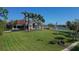 Clubhouse view with a meticulously maintained lawn, palm trees and lake in the background at 4416 Calle Serena, Sarasota, FL 34238