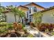 Beautiful home exterior with lush, colorful landscaping and a paved walkway leading to the front door at 4416 Calle Serena, Sarasota, FL 34238