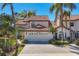 Charming home with red tile roof, a two-car garage and mature tropical landscaping around the house at 4416 Calle Serena, Sarasota, FL 34238