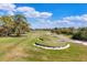 Scenic view of a well-maintained golf course with lush greenery and sand traps under a blue sky at 4416 Calle Serena, Sarasota, FL 34238