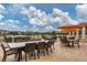 Relaxing outdoor dining area with tables, seating, and orange umbrellas overlooking the green golf course at 4416 Calle Serena, Sarasota, FL 34238