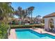 Community pool with lounge chairs, cabana, red-tiled roofs, and palm trees surrounded by lush landscaping at 4416 Calle Serena, Sarasota, FL 34238