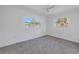 Bright bedroom with neutral carpet, ceiling fan, and two windows offering natural light at 4461 Maceachen Blvd, Sarasota, FL 34233