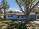 Charming single-story home with mature trees, a gray roof, and well-maintained landscaping at 4461 Maceachen Blvd, Sarasota, FL 34233