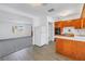 Kitchen with wood cabinets that opens to living room with large window and front door at 4461 Maceachen Blvd, Sarasota, FL 34233