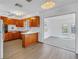 View of the kitchen showcasing wood cabinets and an opening to a sunroom and pool area at 4461 Maceachen Blvd, Sarasota, FL 34233