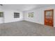 Spacious living room with large windows, grey carpet, and a wooden front door at 4461 Maceachen Blvd, Sarasota, FL 34233