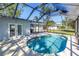 Inviting screened in-ground pool with a concrete patio and lush backyard at 4461 Maceachen Blvd, Sarasota, FL 34233