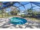 Relaxing in-ground pool in screened lanai, surrounded by lush landscaping and blue sky at 4461 Maceachen Blvd, Sarasota, FL 34233