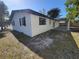 A side view of a well-kept home with a light colored exterior, fenced in yard, and covered patio at 4490 Indianapolis Ne St, St Petersburg, FL 33703