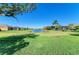 Picturesque backyard view with mature trees, lush green lawn, and serene water views at 4610 Royal Dornoch Cir, Bradenton, FL 34211