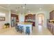 Spacious kitchen featuring a central island, granite countertops, wooden cabinets, and barstool seating at 4610 Royal Dornoch Cir, Bradenton, FL 34211