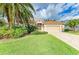 Inviting front yard showcasing lush green lawn, mature landscaping, and a brick-paved driveway leading to the home at 5308 88Th E St, Bradenton, FL 34211