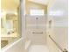 Bright shower features white tile, a glass block window, built-in bench, and safety bars at 5308 88Th E St, Bradenton, FL 34211