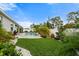 Beautifully landscaped backyard with a pool, vibrant green grass, and lush tropical plants at 559 Spotted Slipper Pl, Ruskin, FL 33570
