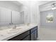 This bathroom features a dual sink vanity, marble countertop, and access to the bedroom at 559 Spotted Slipper Pl, Ruskin, FL 33570