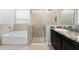 Modern bathroom featuring a separate tub and glass shower with granite countertop at 559 Spotted Slipper Pl, Ruskin, FL 33570