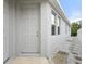 Front door and landscaped walkway to the side of the house with a row of windows at 559 Spotted Slipper Pl, Ruskin, FL 33570