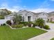 Well-manicured front yard with vibrant green grass and tropical landscaping at 559 Spotted Slipper Pl, Ruskin, FL 33570