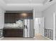 Kitchen includes a stainless steel refrigerator, gray stone backsplash and dark wood cabinets at 559 Spotted Slipper Pl, Ruskin, FL 33570