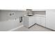 This laundry room features white cabinets, a stainless steel sink, and gray floors at 559 Spotted Slipper Pl, Ruskin, FL 33570