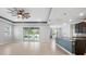 Open-concept living room with backyard pool views, tile flooring, and kitchen with granite counters at 559 Spotted Slipper Pl, Ruskin, FL 33570