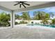 A covered patio with brick flooring overlooks a backyard swimming pool and tropical landscaping at 559 Spotted Slipper Pl, Ruskin, FL 33570
